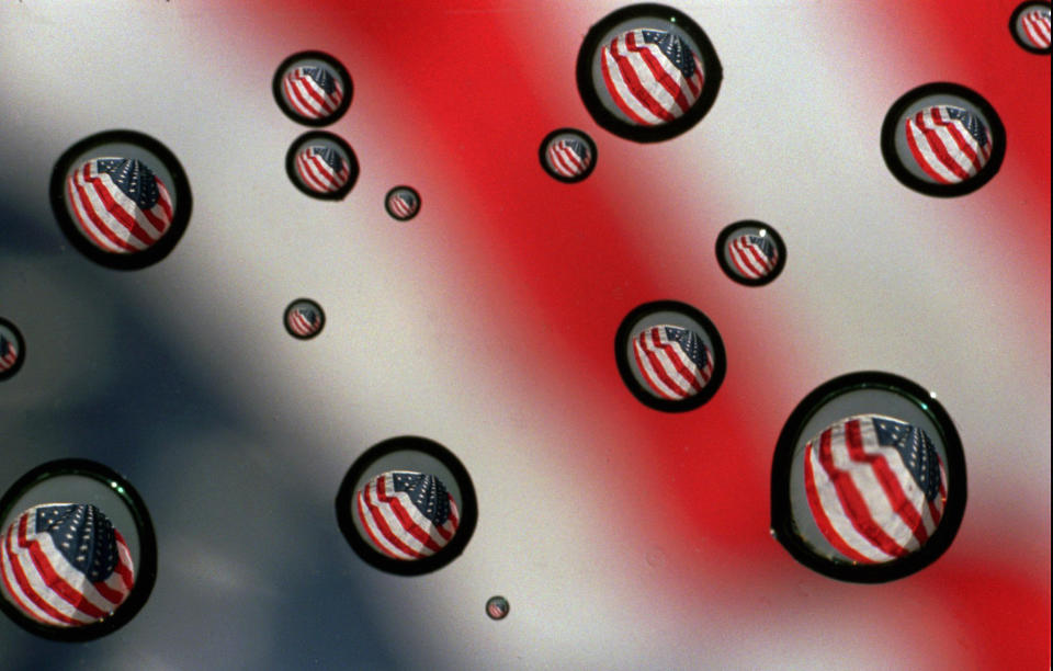 In this Nov. 10, 1997 file photo,a U.S. flag refracted in water drops on a car windshield in Gorham, Maine. The vast majority of Americans fear the country is losing its identity, but underlying that widespread agreement is equally deep disagreement over what it means to be an American. A new poll from The Associated Press-NORC Center for Public Affairs Research finds the country is torn over what poses the greatest threat to the national way of life. (AP Photo/Carl D. Walsh)