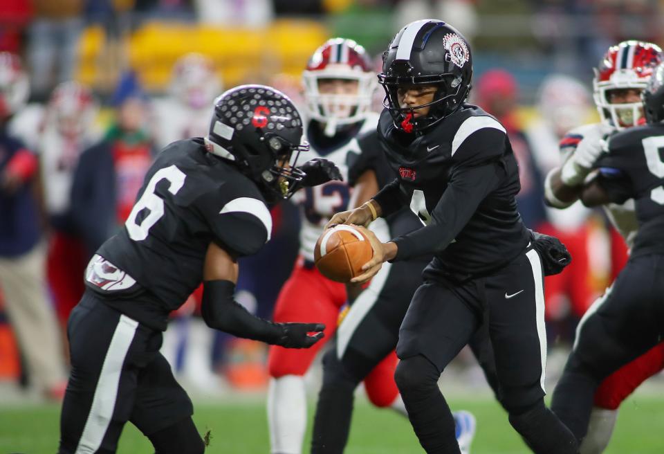 Aliquippa's Quentin Goode (4) hands the ball off to John Tracy (6) during the first half of the WPIAL 4A Championship game against McKeesport Friday evening at Acrisure Stadium in Pittsburgh, PA.