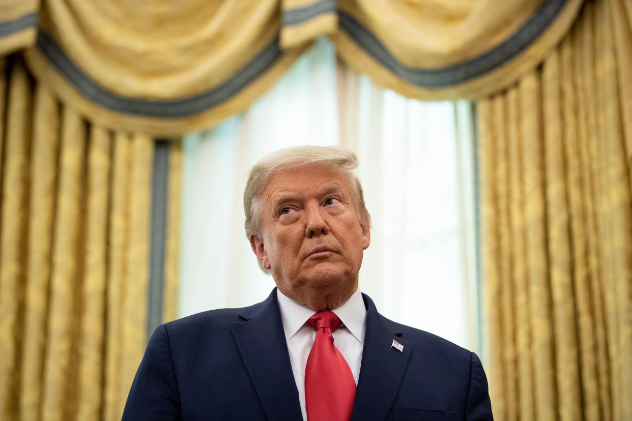 President Trump listens during a Medal of Freedom ceremony for Lou Holtz in the Oval Office on Thursday. (Photo by Brendan Smialowski/AFP via Getty Images)