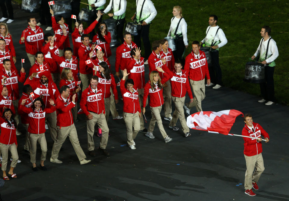 LONDON, ENGLAND - JULY 27: Simon Whitfield of the Canada Olympic triathlon team carries his country's flag during the Opening Ceremony of the London 2012 Olympic Games at the Olympic Stadium on July 27, 2012 in London, England. (Photo by Paul Gilham/Getty Images)