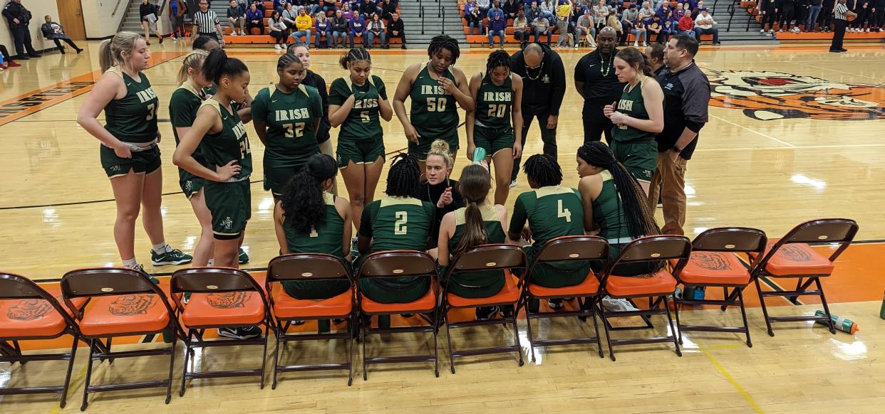 St. Vincent-St. Mary girls basketball coach Carley Whitney, center, gives instructions to her team during a timeout against Bryan in a Mansfield Division II Regional semifinal