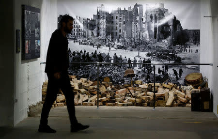 A museum staff walks past artifacts during a media tour of the exhibition entitled 'Hitler - How Could it Happen?' about German Nazi leader Adolf Hitler in a World War Two bunker in Berlin, Germany, July 27, 2017. REUTERS/Fabrizio Bensch