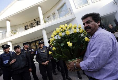 A man carries a bouquet of yellow roses outside the funeral home where the body of Colombian Nobel Prize laureate Gabriel Garcia Marquez was taken in a hearse in Mexico City