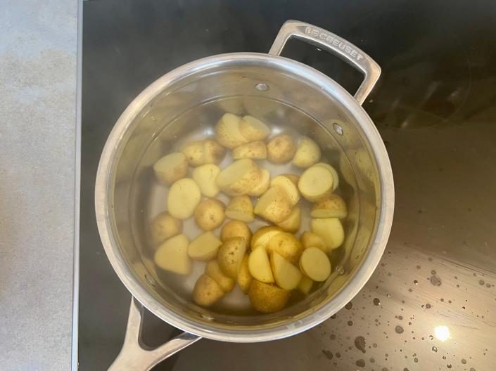 The first step is to parboil the chopped potatoes.