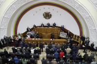 National Assembly President Jorge Rodriguez, top center, swears in Venezuela's new National Electoral Council directors, during an extraordinary session at the National Assembly in Caracas, Venezuela, Tuesday, May 4, 2021. The National Assembly, with an overwhelming pro-government majority, on Tuesday appointed two recognized opponents as members of the new board of the National Electoral Council of Venezuela. (AP Photo/Ariana Cubillos)