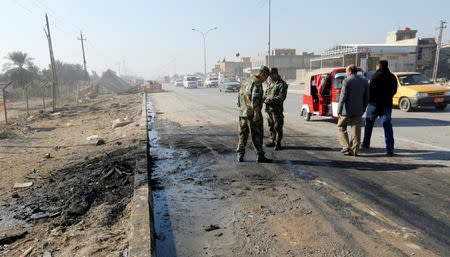 Iraqi security forces stand at the site of car bomb attack in the predominately Shi'ite Muslim neighbourhood of al-Obaidi, Iraq, January 5, 2017. REUTERS/Wissm al-Okili