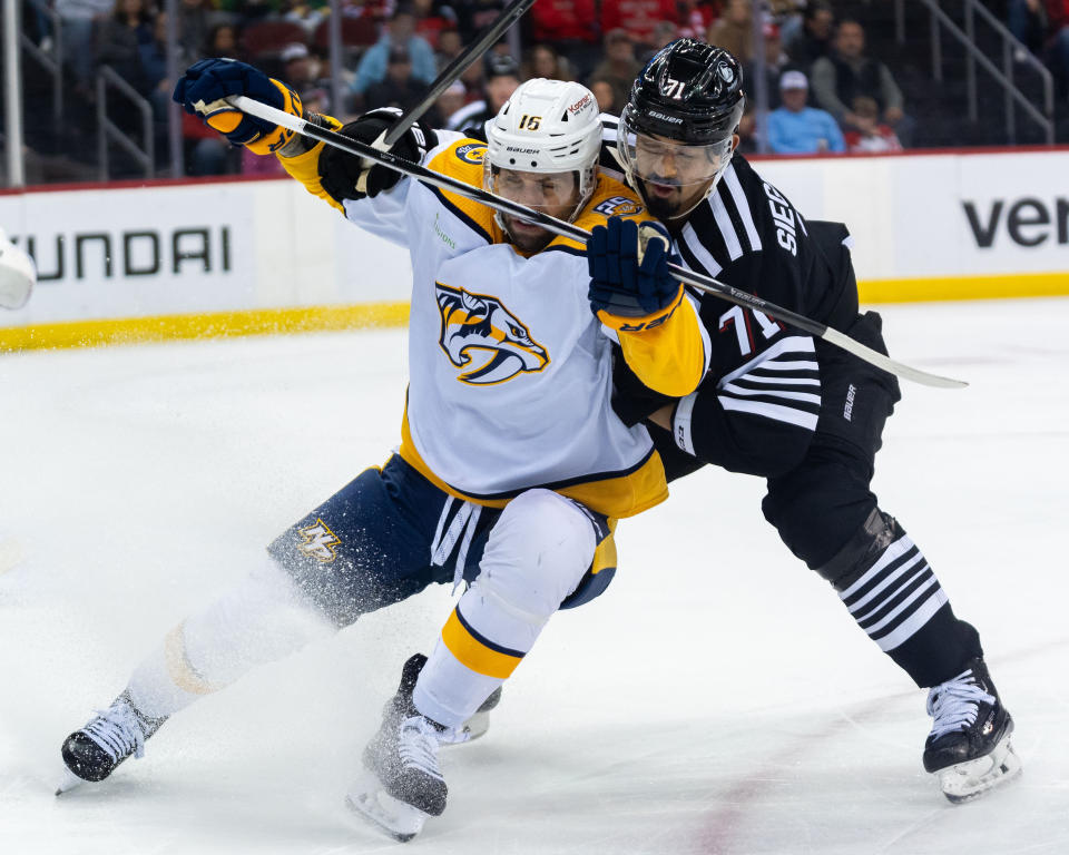 Nashville Predators left wing Jason Zucker, front, fends off New Jersey Devils defenseman Jonas Siegenthaler (71) during the first period of an NHL hockey game in Newark, N.J., Sunday, April 7, 2024. (AP Photo/Peter K. Afriyie)