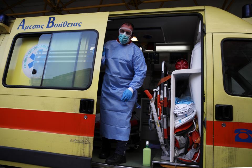 A paramedic wearing a suit to protect against coronavirus, closes the door of an ambulance at Evangelismos hospital in Athens, Thursday, Nov. 12, 2020. Greece has imposed a nationwide nightly curfew as the number of COVID-19 cases in the country continues to surge despite a lockdown. (AP Photo/Thanassis Stavrakis)