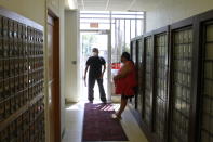 People wait to check their post office boxes in Mission, S.D. on Aug. 6, 2020. The post office is one of four on the Rosebud Indian Reservation. Voter advocates say that people living on reservations must make long trips to check their mail. (AP Photo/Stephen Groves)