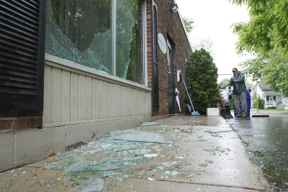 Paul King cleans up broken glass after an early morning firebombing at the CompassCare facility, an anti-abortion center in Amherst, N.Y., on Tuesday, June 7, 2022. (Mark Mulville/The Buffalo News via AP)