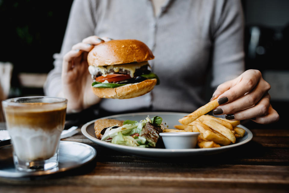 A person eating a burger and fries