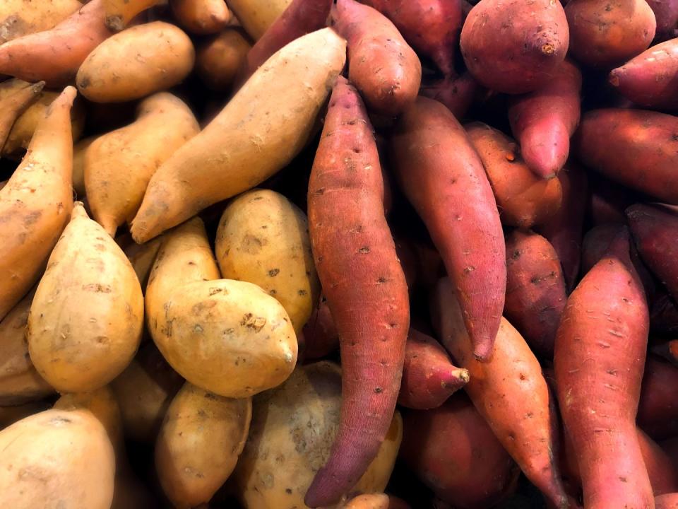 heaps of fresh organic white sweet potatoes at market