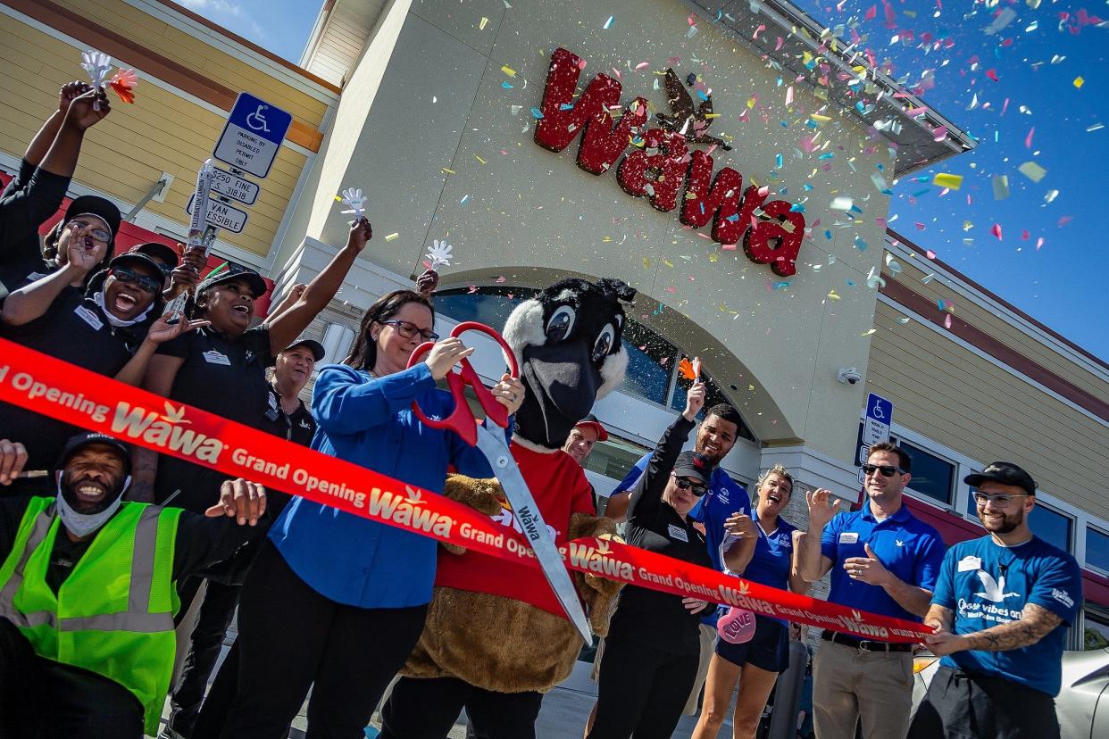 Store manager Danielle Dieter of Jupiter, Fla., cuts the ceremonial red ribbon as Wawa personnel celebrated a grand opening with a new store location at 45th Street and Interstate 95 in West Palm Beach, Fla., on February 9, 2023. 