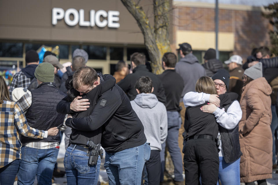 Members of the Burnsville Police Department gathered outside memorials in front of the Burnsville Police Department in Burnsville, Minn., Monday, Feb. 19, 2024. Two police officers and a first responder were shot and killed early Sunday and a third officer was injured at a suburban Minneapolis home in an exchange of gunfire while responding to a call involving an armed man who had barricaded himself inside with family. (Elizabeth Flores/Star Tribune via AP)