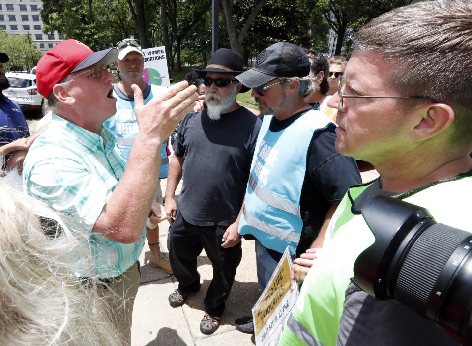 Abortion rights advocates surround Coleman Boyd, left, an anti-abortion supporter, as he tries to disrupt a gathering of rights advocates, Tuesday, May 21, 2019, at the Capitol in Jackson, Miss., during rally to voice their opposition to state legislatures passing abortion bans. (AP Photo/Rogelio V. Solis)