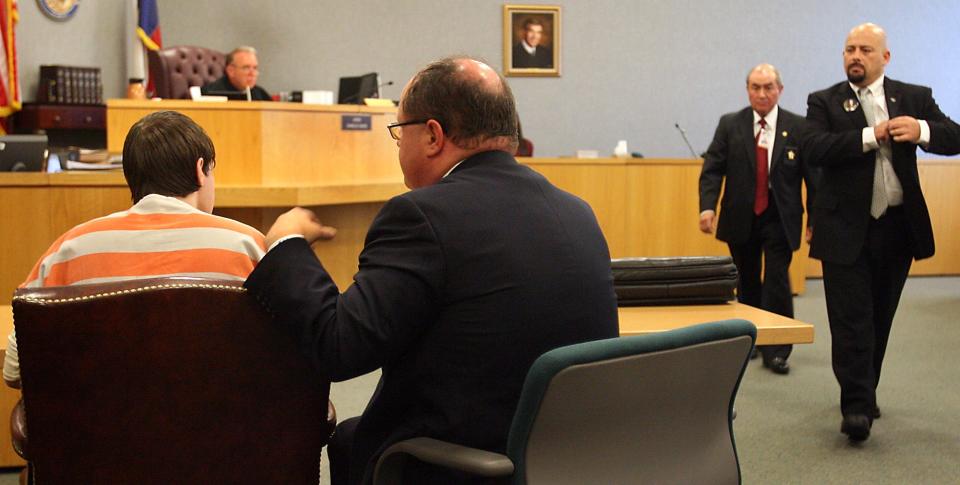 Photo by Larry Kolvoord AMERICAN-STATESMAN....8/1/07....Drew Crecente, right, the father of murder vicitim Jennifer Crecente stares toward Justin Crabbe, 19, left, who had just been sentenced to 35 years in prison for the 2006 murder.   Crecente had just completed a five-minute speech.   Family and friends are allowed to speak before the court and the defendant during this post-sentencing phase before the defendant was taken away.  Seated next to Crabbe is his attorney, Jon Evans, and walking left of Crecente is the court bailiff Art Guerrero.  In the background is District Judge Charlie Baird.