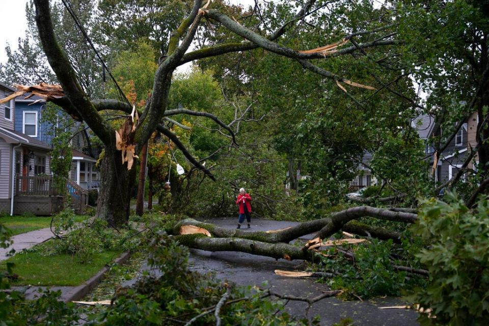 Georgina Scott surveys the damage on her street in Halifax as post tropical storm Fiona continues to batter the area on Saturday, Sept. 24, 2022.  Strong rains and winds lashed the Atlantic Canada region as Fiona closed in early Saturday as a big, powerful post-tropical cyclone, and Canadian forecasters warned it could be one of the most severe storms in the country's history.