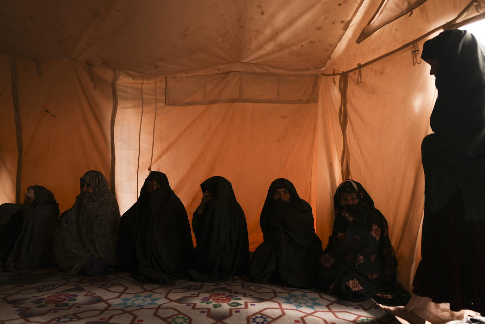 Afghan women gather in the makeshift clinic organised by IFRC in the IDP camp near Qala-e-Naw, Afghanistan, Tuesday, Dec. 14, 2021. Severe drought has dramatically worsened the already desperate situation in Afghanistan forcing thousands of people to flee their homes and live in extreme poverty. Experts predict climate change is making such events even more severe and frequent. (AP Photo/Mstyslav Chernov)