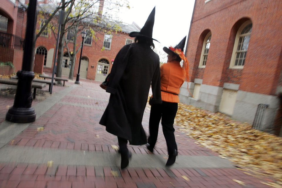 People dressed as witches on the street next to the old Town Hall where the witch trials took place in Salem, MA. (Joe Raedle / Getty Images)