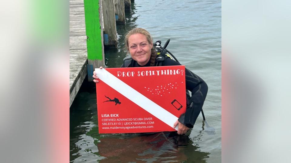 <div>Recovery scuba diver Lisa Eick with a sign for her business, Maiden Voyage Adventures. She finds lost items for individuals around metro Detroit.</div> <strong>(Provided by Lisa Eick)</strong>