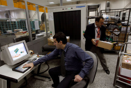 FILE PHOTO - A security official looks at a screen displaying X-ray screened parcels in Turkish Post's (PTT) postal logistic centre at the Ataturk International airport in Istanbul, Turkey on November 6, 2010. REUTERS/Murad Sezer/File Photo