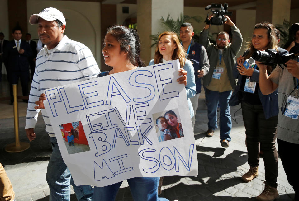 Elsa Ortiz holds a placard with pictures of her son, Anthony David Tobar, who was then at a shelter in Houston. (Photo: Luis Echeverria/Reuters)