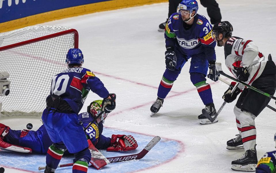 Nicolas Roy of Canada, right, scores his side's third goal against Italy keeper Justin Fazio during the group A Hockey World Championship match between Italy and Canada in Helsinki, Finland, Sunday May 15, 2022. (AP Photo/Martin Meissner)