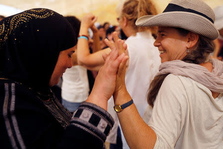 Women celebrate inside a "peace tent" erected as part of an event organised by "Women Wage Peace" group calling for an end to the Israeli-Palestinian conflict, near the Jordan River, in the occupied West Bank October 8, 2017. REUTERS/Ronen Zvulun