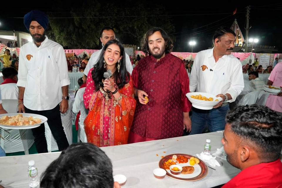 Groom Anant Ambani, center right, and bride Radhika Merchant, center left interacting with guests during a community food service held as part of their pre-wedding celebrations at Jogvad village near Jamnagar, India on Wednesday, Feb.28, 2024.