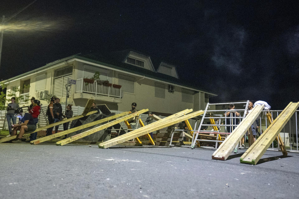 Residents stand in a blockade in Noumea, New Caledonia, Wednesday, May, 15, 2024. Violence is raging across New Caledonia for the third consecutive day and France has imposed a state of emergency in the French Pacific territory. (AP Photo/Nicolas Job)