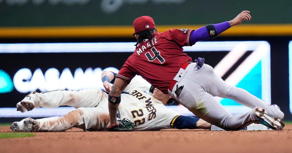 The Diamondbacks' Ketel Marte tags out Brewers leftfielder Christian Yelich after Yelich rounded the bag and then tried to dive back in the sixth inning Tuesday night.