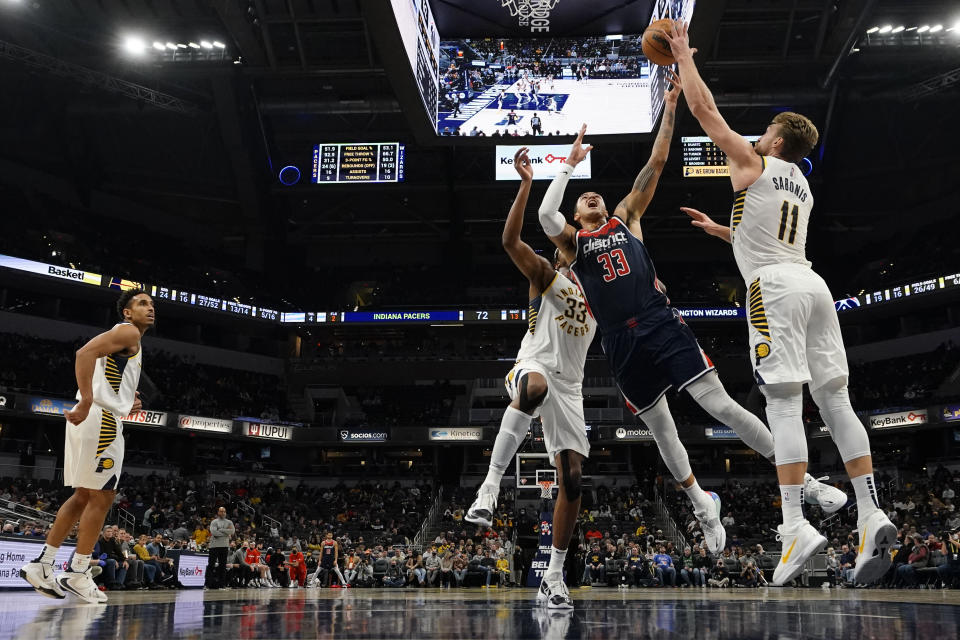 Washington Wizards forward Kyle Kuzma (33) has his shot blocked by Indiana Pacers forward Domantas Sabonis (11) during the second half of an NBA basketball game in Indianapolis, Monday, Dec. 6, 2021. (AP Photo/AJ Mast)