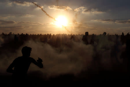 Palestinians run from tear gas during a protest calling for lifting the Israeli blockade on Gaza and demanding the right to return to their homeland, at the Israel-Gaza border fence, in the southern Gaza Strip September 21, 2018. REUTERS/Ibraheem Abu Mustafa