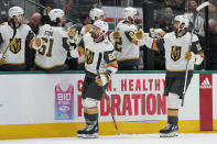 Vegas Golden Knights' William Carrier (28) and Nicolas Roy (10) celebrate with the team after Carrier scored in the first period of Game 6 of the NHL hockey Stanley Cup Western Conference finals against the Dallas Stars, Monday, May 29, 2023, in Dallas. (AP Photo/Tony Gutierrez)