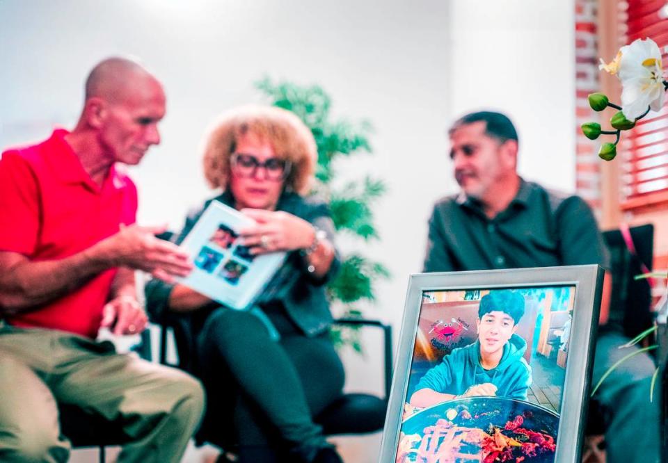 The parents of Derbin Huertas Jr., Ana and Derbin Sr., share family photos with cornea recipient Art Durshimer at Lions World Vision Institute in Ybor City. Ricky De Silva/Provided by Lions World Vision Institute