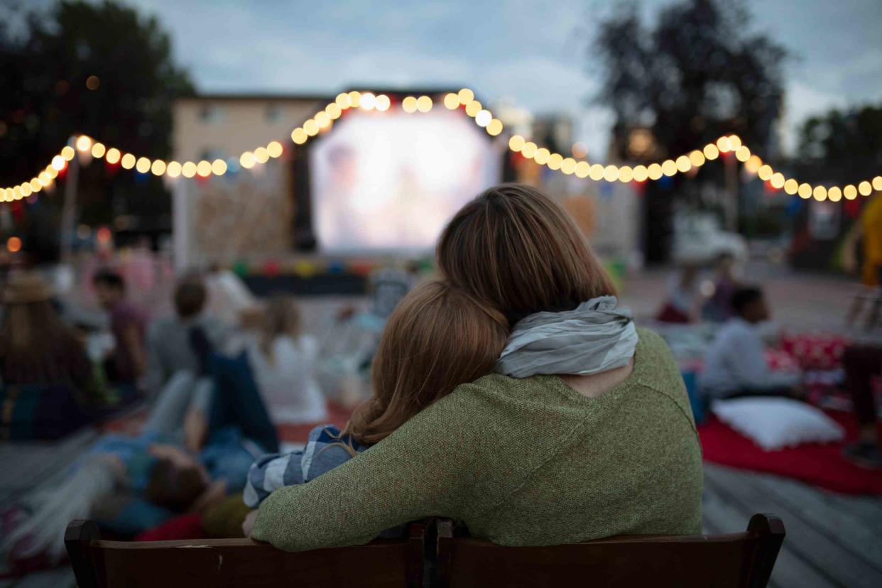 woman hugging daughter watching movies