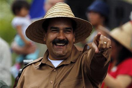 Venezuela's President Nicolas Maduro greets supporters during a rally with farmers in Caracas February 26, 2014. Pope Francis called on Wednesday for an end to violence in Venezuela that has killed at least 13 people and urged politicians to take the lead in calming the nation's worst unrest for a decade. REUTERS/Tomas Bravo