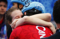 Winner Canada's Charles Hamelin hugs his girlfriend and compatriot speed skater Marianne St-Gelais after the men's 1,500 metres short track speed skating race finals at the Iceberg Skating Palace during the 2014 Sochi Winter Olympics February 10, 2014. REUTERS/David Gray (RUSSIA - Tags: OLYMPICS SPORT SPEED SKATING)