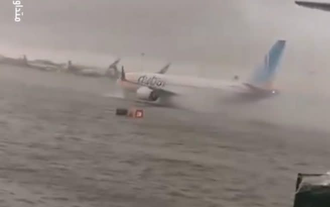 A plane taxis through floodwaters that caused Dubai's international airport to close