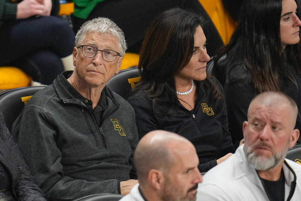 Bill Gates, left, sits with his girlfriend, Paula Hurd, during the first half of an NCAA college basketball game between Baylor and Cornell, Tuesday, Jan. 2, 2024, in Waco, Texas. (AP Photo/Julio Cortez)