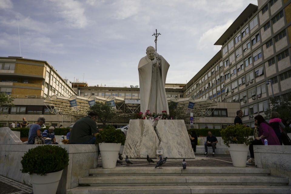 A statue of Saint John Paul II towers at the entrance of the Agostino Gemelli University Polyclinic in Rome, Friday, June 9, 2023, where Pope Francis is recovering after undergoing abdominal surgery on Wednesday. The Vatican says Pope Francis has had a second good night in the hospital recovering from surgery to remove intestinal scar tissue and repair a hernia in his abdominal wall.(AP Photo/Alessandra Tarantino)
