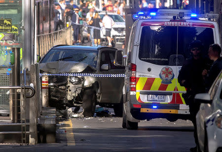 Australian police stand near a crashed vehicle after they arrested the driver of a vehicle that had ploughed into pedestrians at a crowded intersection near the Flinders Street train station in central Melbourne, Australia December 21, 2017. REUTERS/Luis Ascui