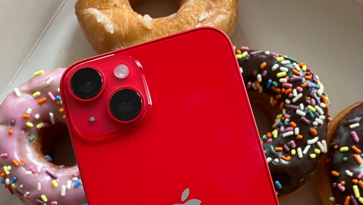  IPhone shown over donuts in bright red color. 