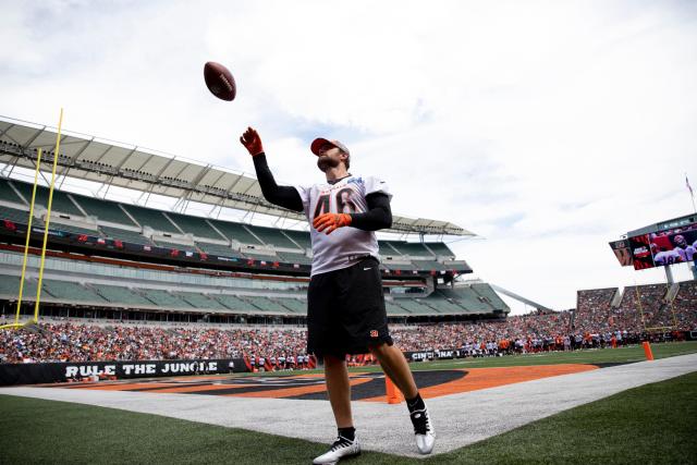 Cincinnati Bengals long snapper Clark Harris tosses a football to