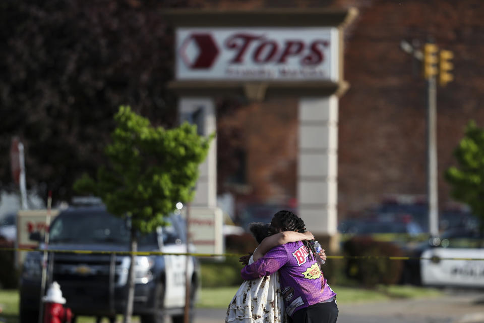 FILE - People hug outside the scene after a shooting at a supermarket on May 14, 2022, in Buffalo, N.Y. The NAACP, the nation's oldest civil rights organization said it will propose a sweeping plan meant to protect Black Americans from white supremacist violence, in response to a hate-fueled massacre that killed 10 Black people in Buffalo, New York last weekend. (AP Photo/Joshua Bessex, File)