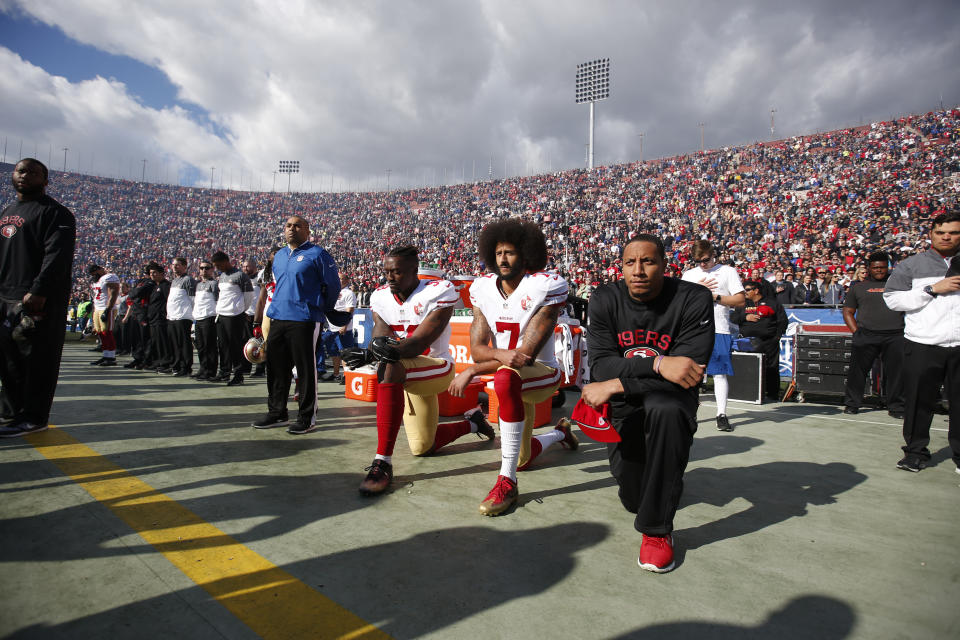 Kaepernick (centre) went on to take the knee at future NFL games during the US national anthem, and was joined by 49ers teammates. (Getty)