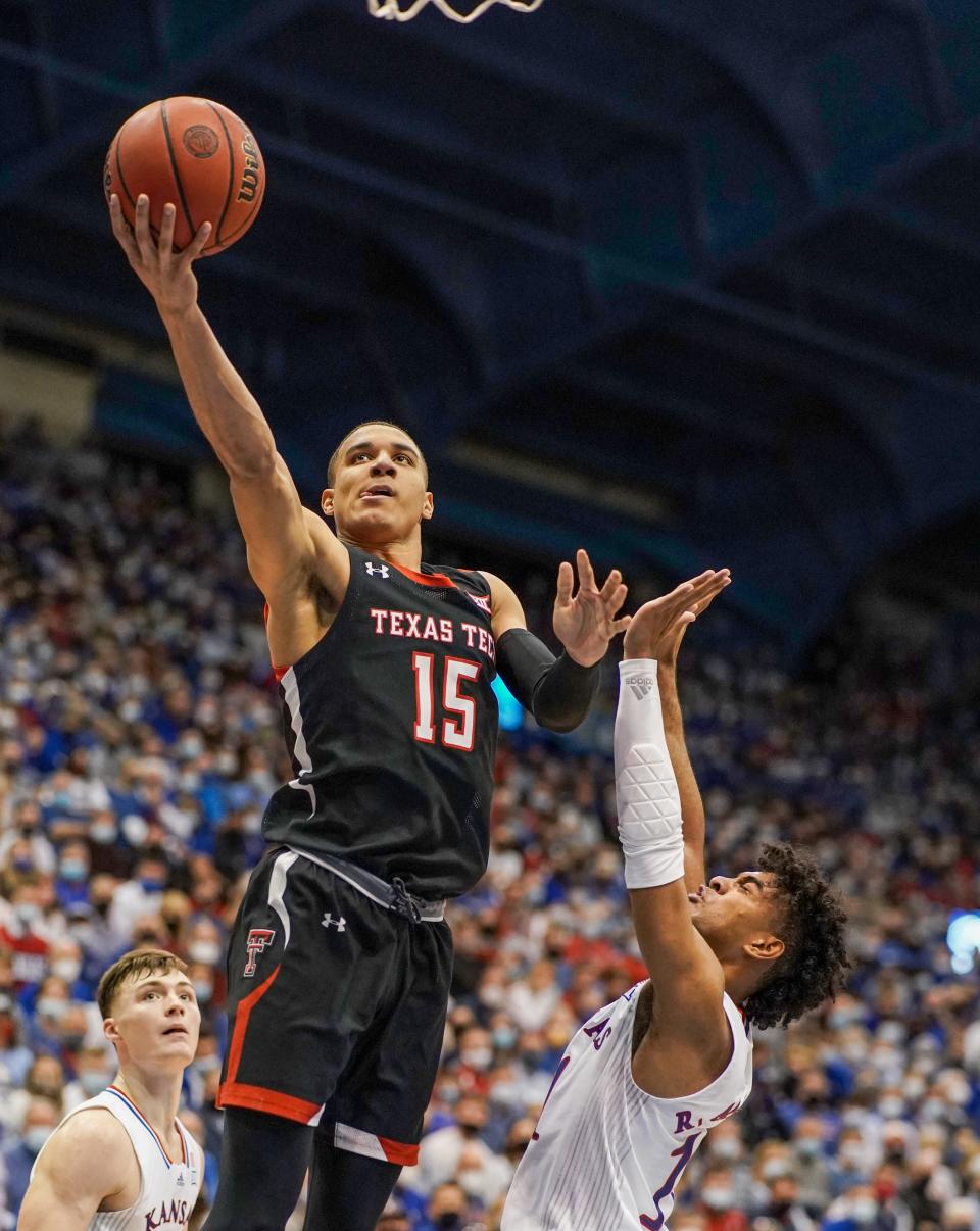 Texas Tech Red Raiders guard Kevin McCullar (15) shoots a layup as Kansas Jayhawks guard Remy Martin (11) defends during the first half Monday at Allen Fieldhouse.