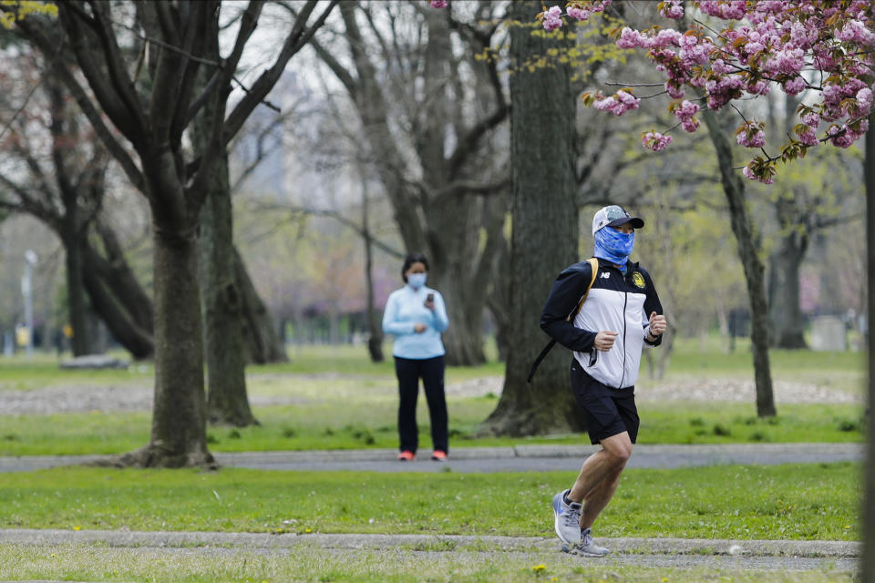 People wearing masks enjoy Flushing Meadows-Corona park Thursday, April 23, 2020, in the Queens borough of New York. (AP Photo/Frank Franklin II)