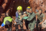 Following an overnight emergency operation, rescue workers and military carry a 1 year-old from a deep hole in the northern Thailand province of Tak, 420 kms. (260 miles) north of Bangkok, Tuesday, Feb. 7, 2023. The toddler, who is from Myanmar, fell into the 15 meter deep hole used for groundwater pipes yesterday evening. (AP Photo/Chiravuth Rungjamratratsami)