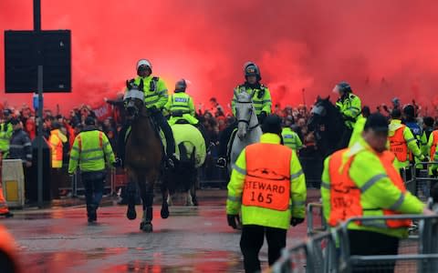 Liverpool versus AS Roma; mounted police emerge from the smoke flares - Credit: Getty Images